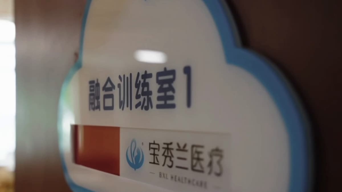 「融合训练室 1」的云朵形门牌,下方是宝秀兰医疗的标志