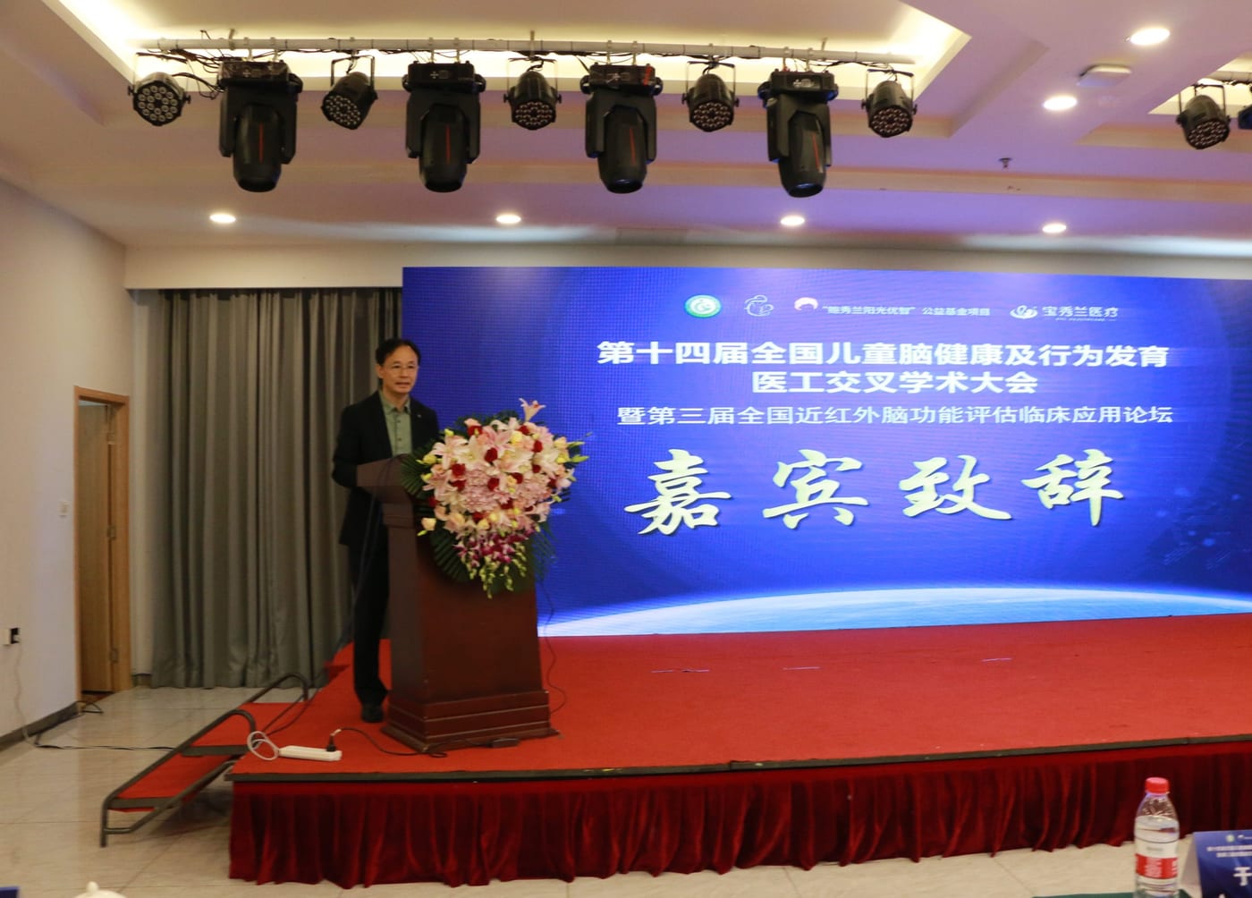 成家树副会长在讲台前致辞,身后是大会背景板