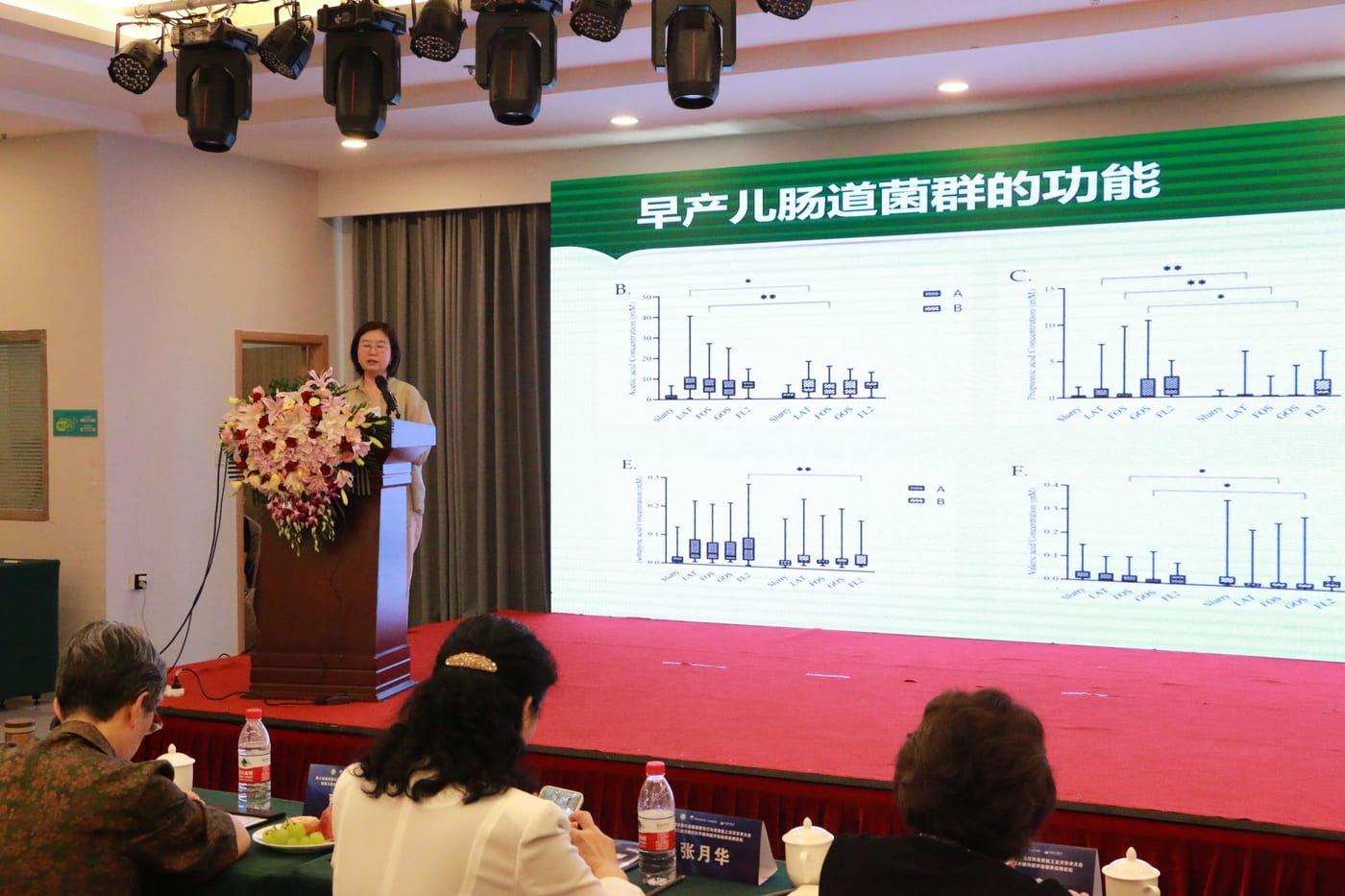李正红教授在讲台前作报告,大屏幻灯片标题为「早产儿肠道菌群的功能」