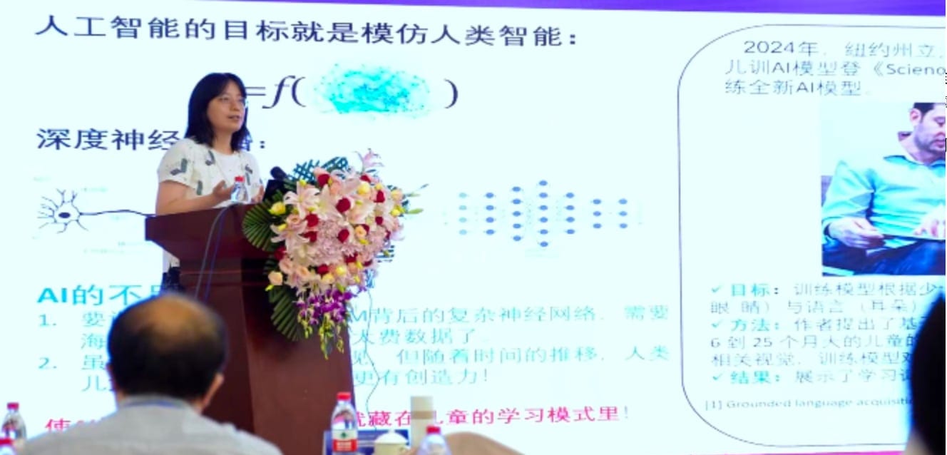 杨旸教授在讲台后作报告,幻灯片标题为「人工智能的目标就是模仿人类智能」