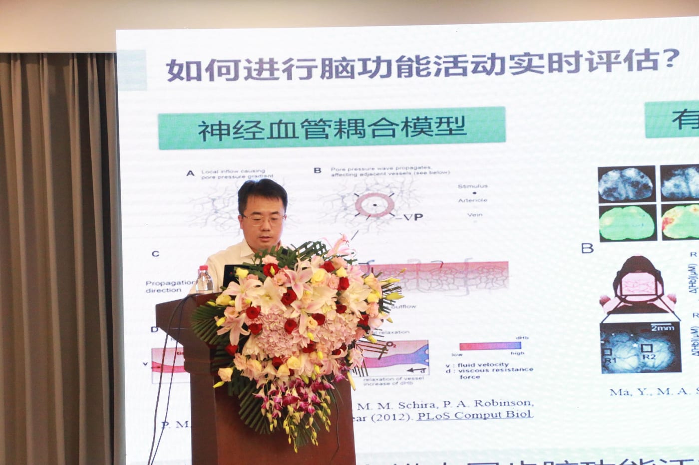 张鑫教授在讲台前作报告,大屏幻灯片标题为「如何进行脑功能活动实时评估?」