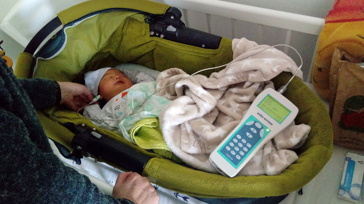 新生儿听力筛查:给熟睡的婴儿戴上探头做耳声发射检查
