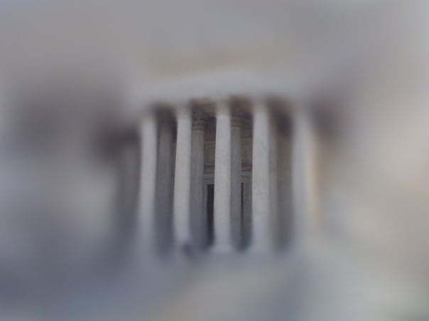 模拟管状视野的照片:画面中央一小块还看得清建筑物的立柱,四周全部模糊发暗,是视野由周边向中心收窄以后看到的样子