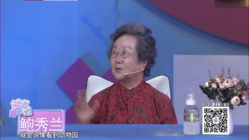 《妈妈育上娃》演播室里鲍秀兰教授出镜，身后的屏幕上是 0–3 岁宝宝语言发育情况对照表